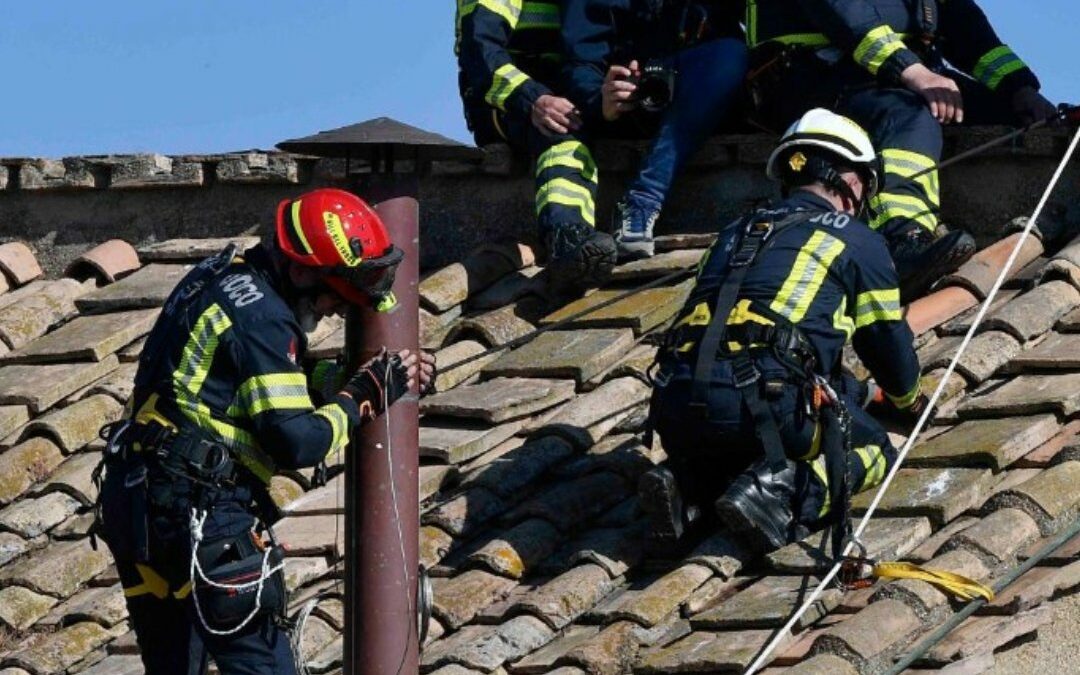 Vatican firefighters install a chimney on the roof of the Sistine Chapel for the papal election